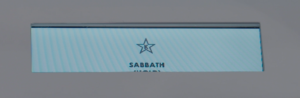 A rectangular sign displays a star icon above the word "SABBATH" in capital letters on a light blue background.